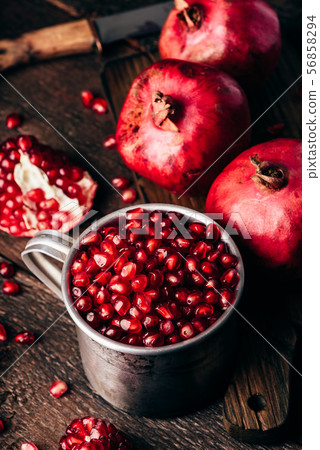 Metal rustic mug full of pomegranate seeds 56858294