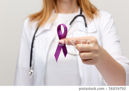 Lymphoma concept. Purple ribbon in the hand isolated. Lymphoma concept. Purple ribbon in the hand isolated. 56859792