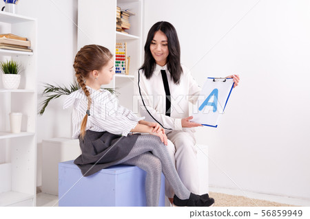 Child with therapist working on pronunciation and sounds together sitting in the class. 56859949