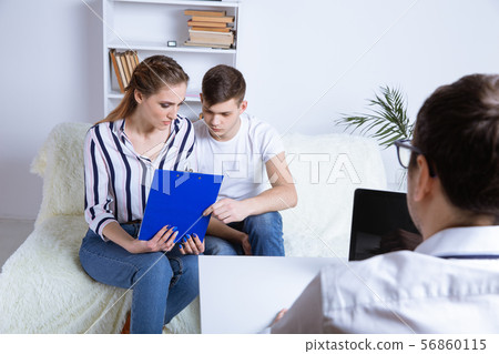 Couple consulting with professional about property questions. 56860115