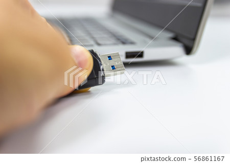 hand man hold Flash drive connect to USB port 56861167