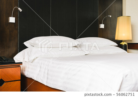Beautiful luxury comfortable white pillow and blanket on bed with light lamp Beautiful luxury comfortable white pillow and blanket on bed with light lamp 56862751