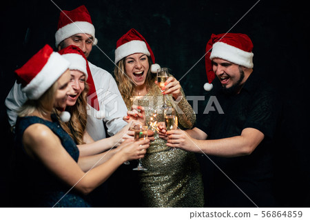 Friends celebrate clinking with champagne glasses Friends celebrate clinking with champagne glasses 56864859