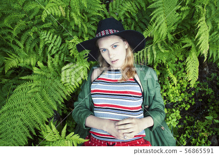 Pretty young blond girl hipster in hat among fern, vacation in green forest, lifestyle people 56865591