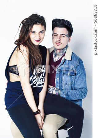 Young couple together. guy with tattoo, girlfriend wearing dreadlocks having fun on white background Young couple together. guy with tattoo, girlfriend wearing dreadlocks having fun on white background 56865719