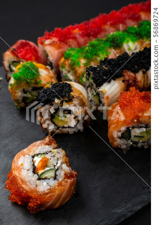 Sushi roll Philadelphia with salmon, smoked eel, avocado, cream cheese on black background. Sushi 56869724