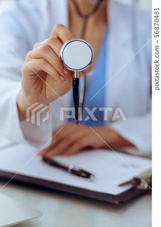 Doctor with a stethoscope in the hands, close up. Physician ready to examine and help patient 56870481