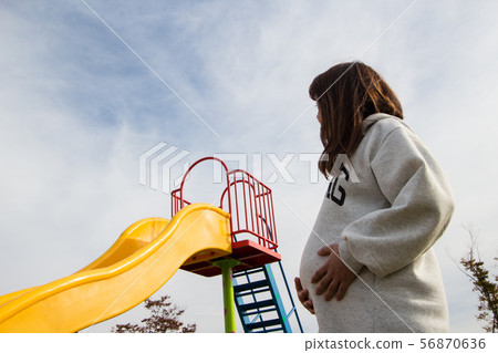 Pregnant woman looking up to the sky Pregnant woman looking up to the sky 56870636