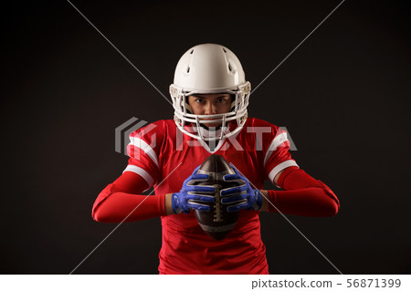 Photo of american female football player in helmet with rugby ball in hands Photo of american female football player in helmet with rugby ball in hands 56871399