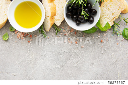 Sliced fresh crusty baguette with olive and spices Sliced fresh crusty baguette with olive and spices 56873367