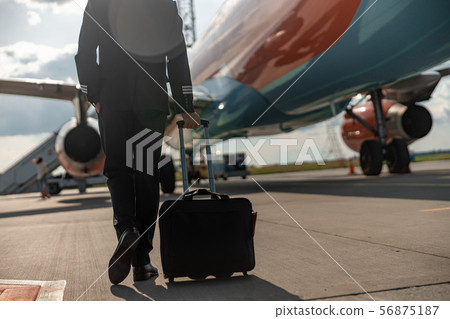 Mature pilot hurrying for the flight at airport Mature pilot hurrying for the flight at airport 56875187