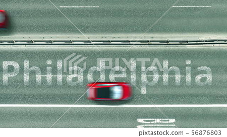 Aerial down view of the motorway with cars revealing Philadelphia caption. Car travel to the United Aerial down view of the motorway with cars revealing Philadelphia caption. Car travel to the United 56876803