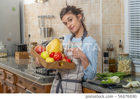 smiling young woman with fruits in the kitchen smiling young woman with fruits in the kitchen 56876890