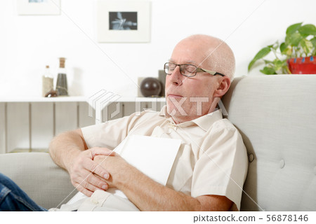mature man taking a nap in sofa at home mature man taking a nap in sofa at home 56878146