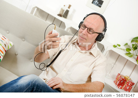 handsome mature man listening to music with handsome mature man listening to music with 56878147