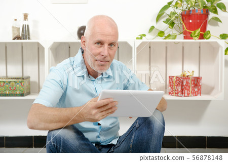 handsome mature man using tablet handsome mature man using tablet 56878148