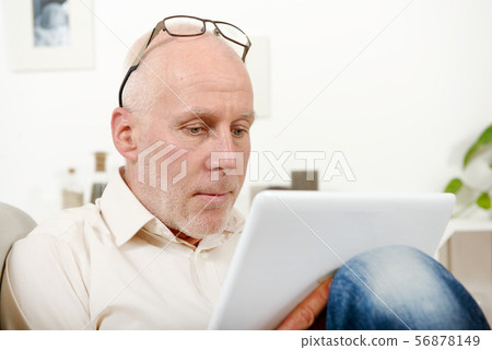 handsome mature man using tablet handsome mature man using tablet 56878149