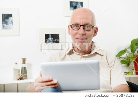handsome mature man using tablet handsome mature man using tablet 56878152