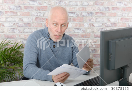 mature businessman opening letter envelope mature businessman opening letter envelope 56878155