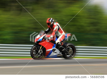 Motorcycle rider racing at high speed on race Motorcycle rider racing at high speed on race 56880506