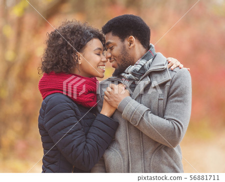 Tender afro couple sharing loving moment in autumn park Tender afro couple sharing loving moment in autumn park 56881711
