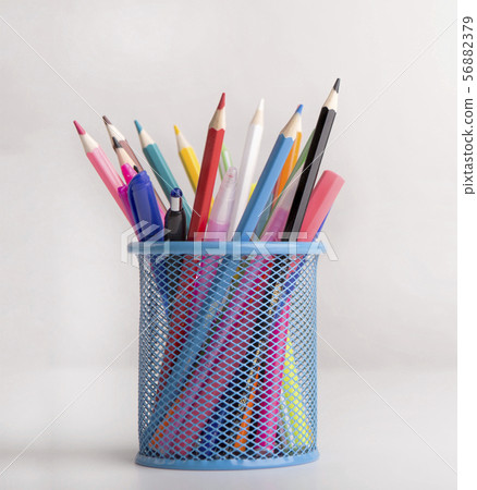 Close up of colored pencils in blue transparent stand on white Close up of colored pencils in blue transparent stand on white 56882379