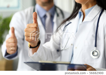 Group of doctors standing in row showing thumb up symbol 56882900
