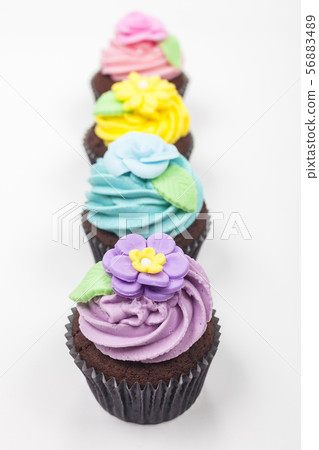 Four Chocolate Cupcakes With Colorful Icing or 56883489
