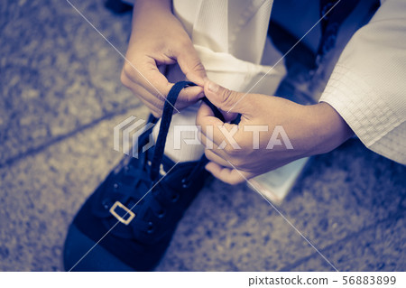 Little boy is tighting shoelaces for himself 56883899