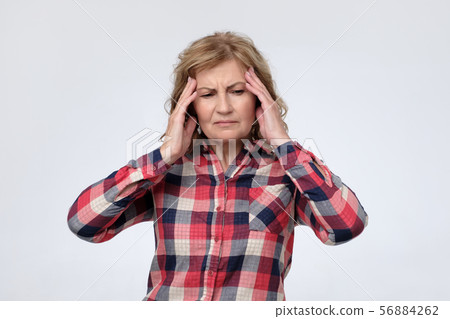 Mature caucasian woman suffering from headache and pain. 56884262