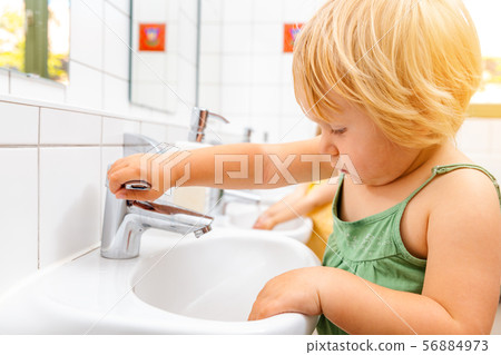 Child in kindergarten washing her hands 56884973