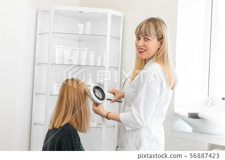 Physician trichologist dermatologist examines the 56887423