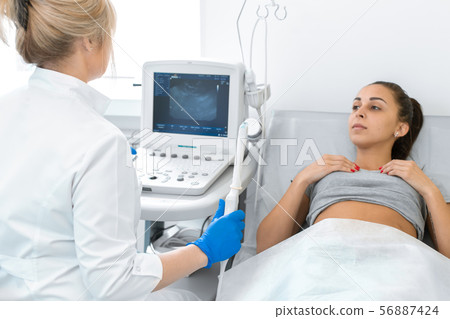 The gynecologist sets up the ultrasound machine The gynecologist sets up the ultrasound machine 56887424