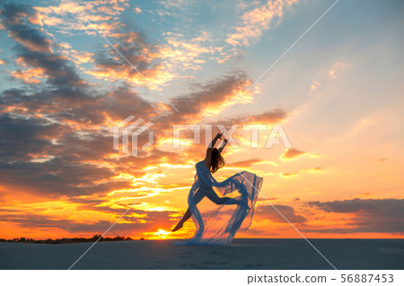 A girl in a fly white dress dances and poses in 56887453