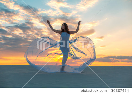 A girl in a fly white dress dances and poses in A girl in a fly white dress dances and poses in 56887454