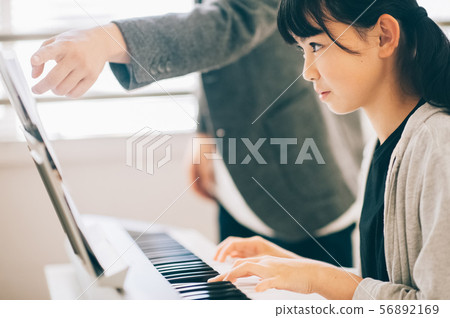 Girls playing electronic piano 56892169