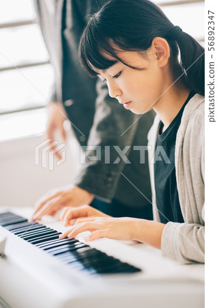 女孩在玩電子鋼琴 56892347