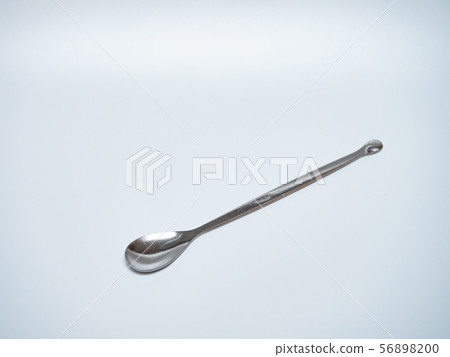 long stainless steel spoon in light grey background 56898200