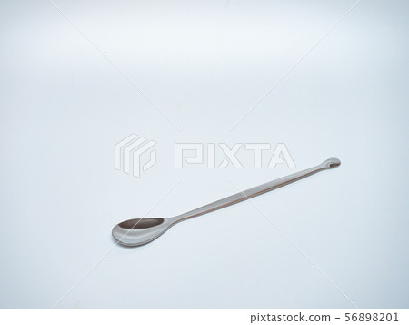 long stainless steel spoon in light grey background long stainless steel spoon in light grey background 56898201