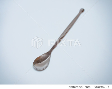 long stainless steel spoon in light grey background 56898203