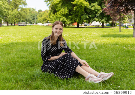 Beautiful young woman sits on the grass. Fresh natural summer concert. Beautiful young woman sits on the grass. Fresh natural summer concert. 56899913