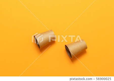 Paper cups in a chaotic position on an orange background with space for text. Minimal flat lay 56900025
