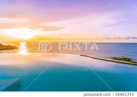 Beautiful outdoor infinity swimming pool in hotel resort with sea ocean view and white cloud blue sky 56901354