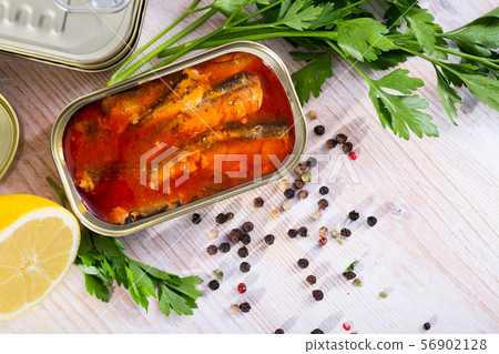 Tinned sardines in tomato sauce on background with greens and lemon Tinned sardines in tomato sauce on background with greens and lemon 56902128