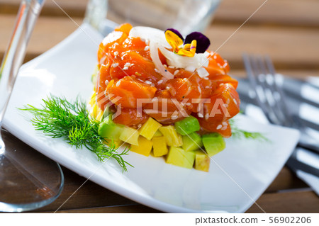 Cube of tasty tartar from red fish and avocado served on plate Cube of tasty tartar from red fish and avocado served on plate 56902206