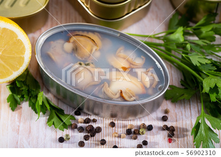 Open tin can with sea clams in its own juice 56902310