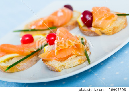 Tapas with salmon, lemon, cranberry 56903208
