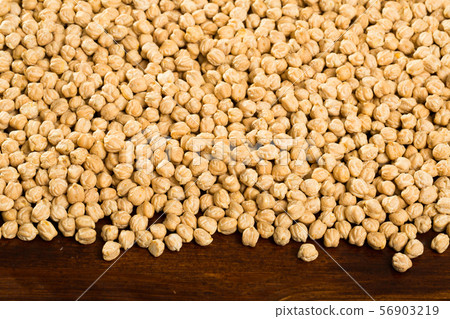Closeup of background with raw garbanzo grains on wooden surface 56903219
