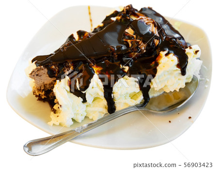 Slice of tasty chocolate cake served on white plate with whipped cream 56903423