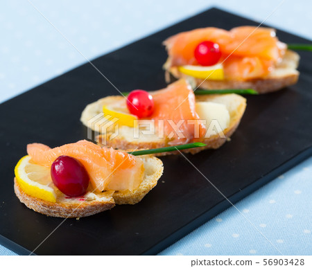 Canapes with salmon, butter and cranberries 56903428